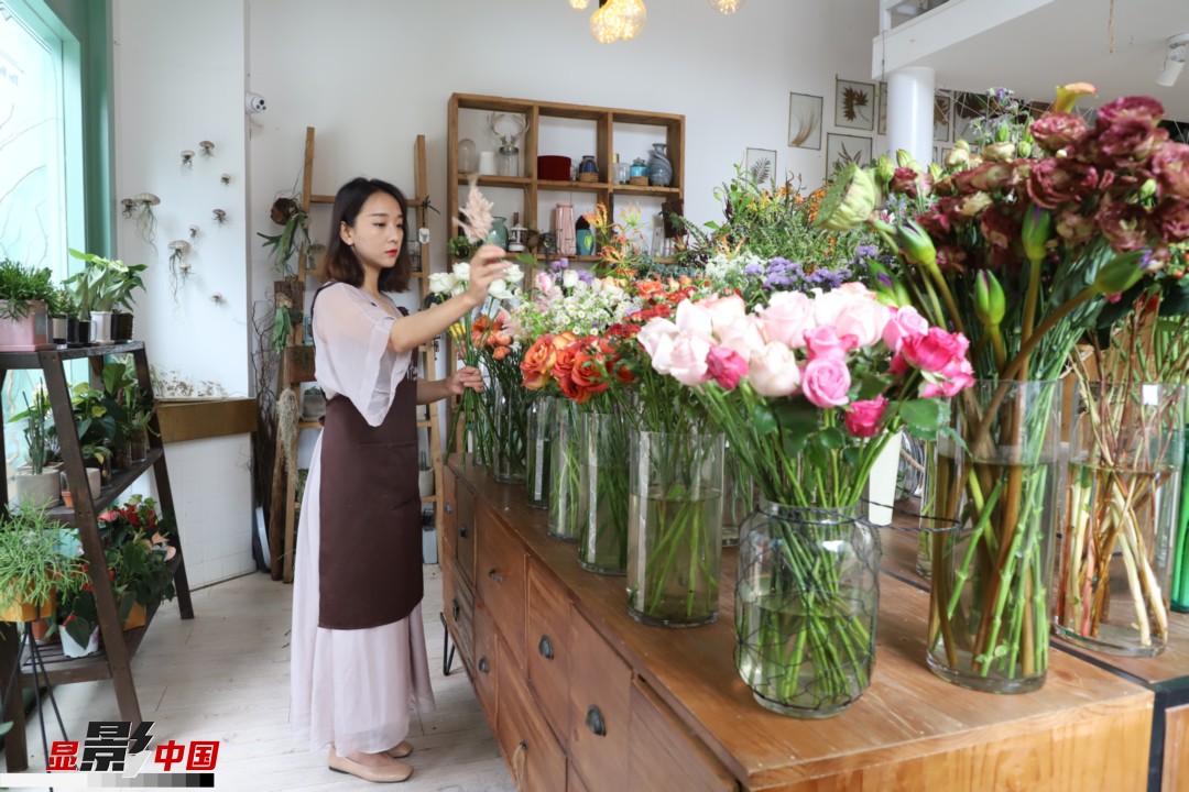 王黎媛是一名河南姑娘，在昆明念完大學(xué)后，就再也舍不下春城的藍(lán)天陽(yáng)光、青山碧水，更舍不下這里的四時(shí)繁花，于是就干脆留了下來(lái)，成了一名媒體人。2017年的時(shí)候又毅然辭去工作，創(chuàng)業(yè)開(kāi)起了花店，成了都市里的一名“花房姑娘”。圖為王黎媛在自己的花店中整理鮮花。新華網(wǎng) 周亞平/攝 念新洪/文