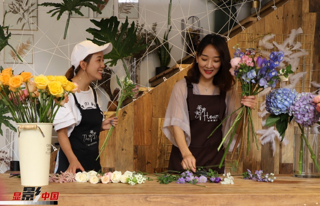 “昆明是鮮花的原產(chǎn)地，有亞洲最大的鮮切花交易市場，可以說具備開花店的天時地利；另外和很多女孩一樣，我從小也就有開花店的夢想！”說起當初的決定，王黎媛說一是因為夢想，另外也跟昆明這個城市產(chǎn)花、賣花的“基因”有關。圖為王黎媛和同事在制作花束。新華網(wǎng) 周亞平/攝 念新洪/文